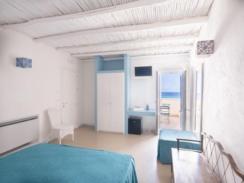 a white room with a bed and a view of the ocean at Tannur B&B in Castellammare del Golfo