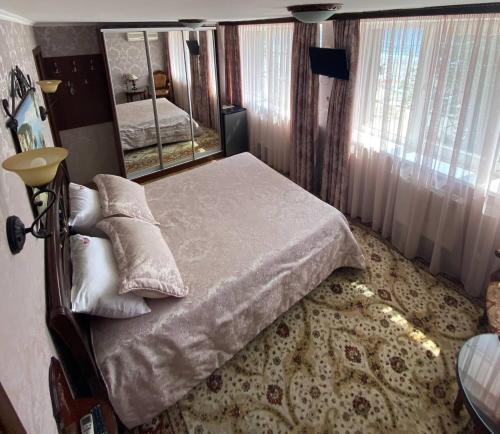- une chambre avec un lit et un grand miroir dans l'établissement Shalanda, à Odessa