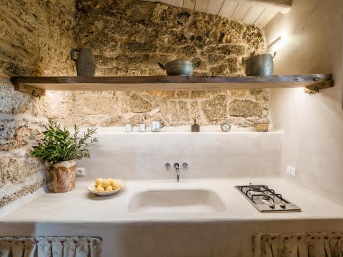 a kitchen with a sink and a stove at Masseria de Li Travaj - in Salento - RivedelSalento in Patù