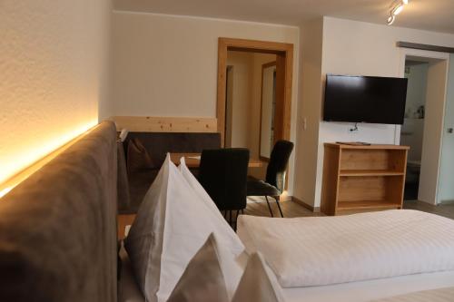 a room with a bed and a desk and a television at Glautschhof in Weissensee