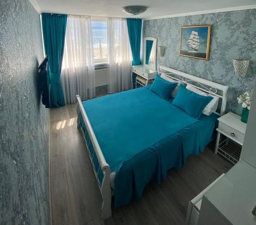 a bedroom with a blue bed and blue curtains at Shalanda in Odesa