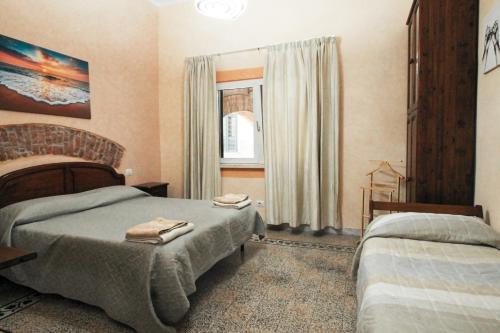 1 dormitorio con 2 camas y ventana en B&B Le Mura en Grosseto