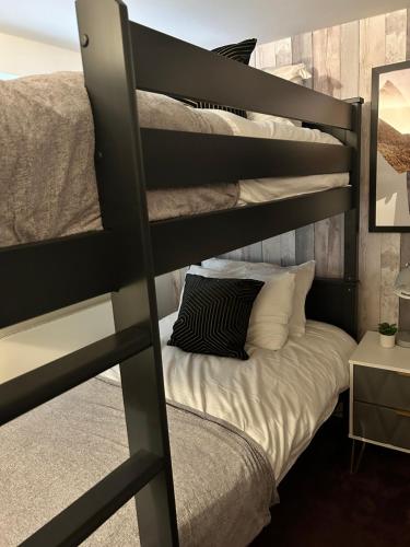 ein Schlafzimmer mit einem Etagenbett mit einem schwarzen Bett in der Unterkunft Sea view apartment on Poole Quay overlooking Sandbanks in Poole