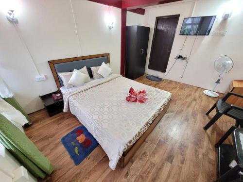 ein Schlafzimmer mit einem Bett mit einer roten Schleife darauf in der Unterkunft Abode Me Me Ai Haven in Cherrapunji