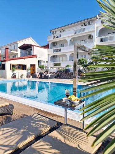 a swimming pool with a table next to a building at Luxury Apartments Silva with sea view in Trogir