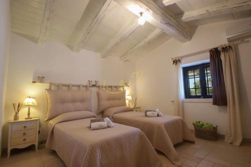 a bedroom with two beds and a window at Trulli Dimore - Trulli della Lama in Castellana Grotte
