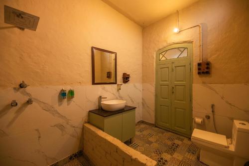 La salle de bains est pourvue d'un lavabo, de toilettes et d'une porte. dans l'établissement Chahal Tree Farm House - 20 min Ride from Golden Temple, à Amritsar