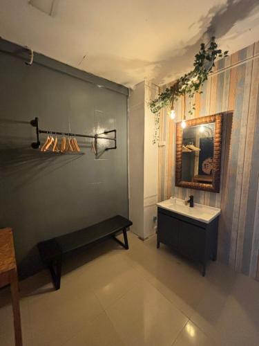 baño con banco, lavabo y espejo en La Locanda en Bangkok