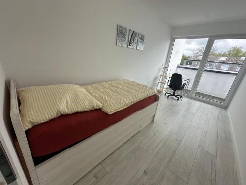 ein Schlafzimmer mit einem Bett und einem großen Fenster in der Unterkunft Neue Doppelhaushälfte mit Terrasse, Balkon und Garten in Remscheid