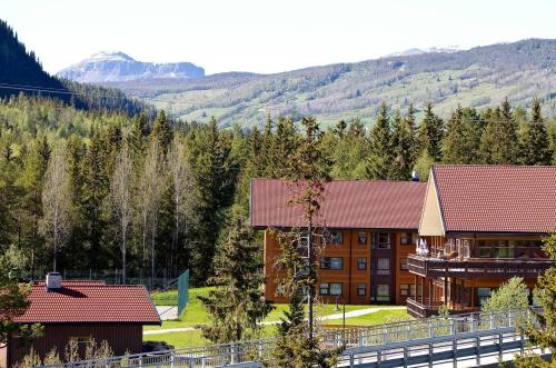 an image of a hotel with mountains in the background at Actif 106 - Hallingheim apartment ski inn/ski ut in Ål