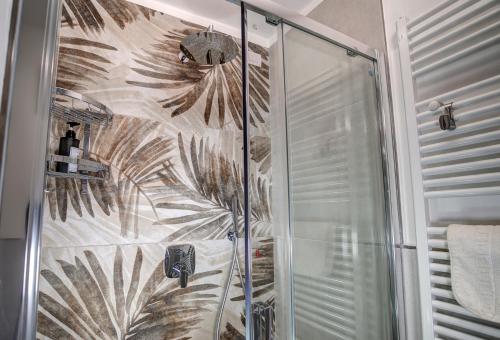 a shower with a glass door with a design on it at Il Colombé B&B in Barzanò