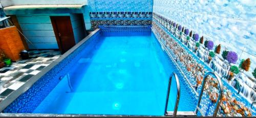 a swimming pool with blue water in a building at HOTEL TASTE OF INDIA in Agra