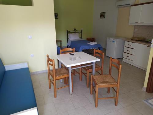 Habitación con mesa, sillas y cama en Studio Μαρίνος 'Αγιοι Απόστολοι Πετριές, en Agioi Apostoli