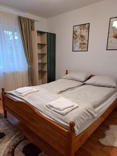 um quarto com uma cama grande com duas toalhas em DÉNY APARTMAN em Sfântu Gheorghe