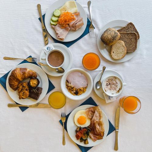 une table garnie d'assiettes de nourriture et de boissons pour le petit-déjeuner dans l'établissement Villaggio Planetarium Resort, à Bibione