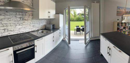 a kitchen with white cabinets and black counter tops at Ferienhaus Paulsen in Breklum