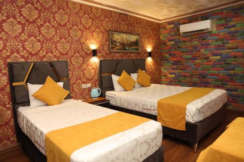 a hotel room with two beds and a brick wall at Adana Saray Hotel in Adana