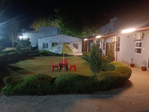 a table and chairs in the yard of a house at night at Swastik Garden and Hotel & Resort in Vrindāvan