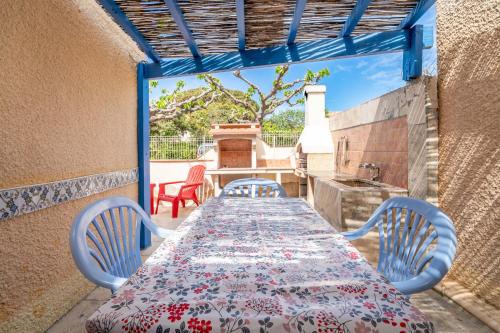 une table et des chaises sur une terrasse avec une cuisine dans l'établissement Maison Fleurynes, à Fleury