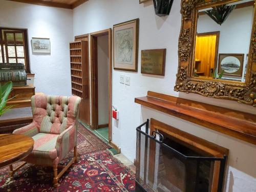a living room with a chair and a mirror at Coach House Hotel & Spa Tzaneen in Tzaneen