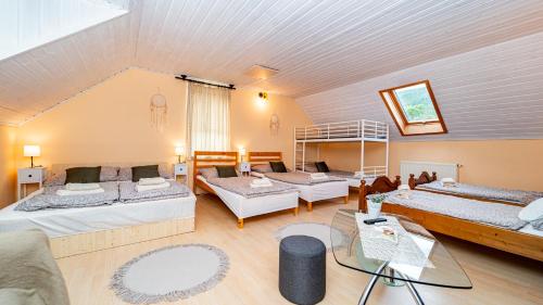 a large room with three beds in it at Kútvölgy Vendégház in Vác