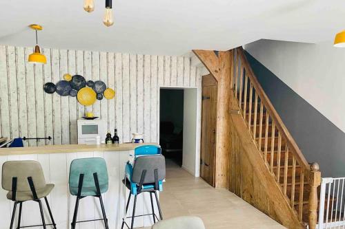 une cuisine avec des tabourets bleus et gris et un comptoir dans l'établissement Gîte au bord de la Gironde, à La Reuille