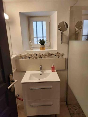 une salle de bain avec un lavabo et une fenêtre dans l'établissement Gîte au bord de la Gironde, à La Reuille