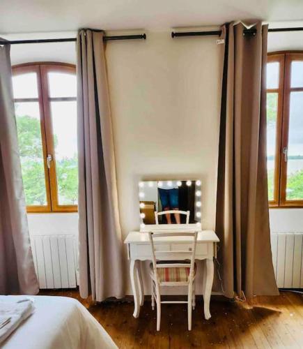 - une chambre avec un bureau blanc et un miroir dans l'établissement Gîte au bord de la Gironde, à La Reuille