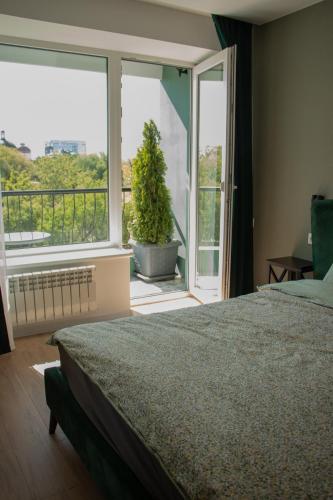 a bedroom with a bed and a window with a potted plant at Central City Park Panorama View in Chişinău