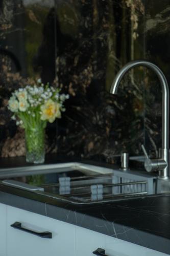 a kitchen sink with a vase of flowers in it at Central City Park Panorama View in Chişinău