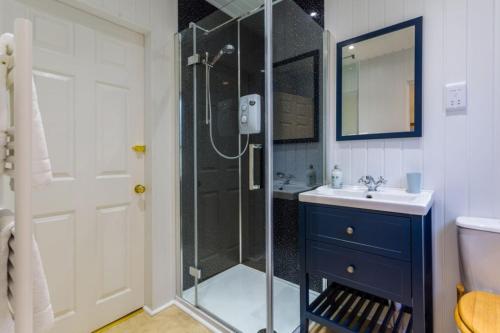 a bathroom with a glass shower and a sink at The Bungalow - Ardullie Lodge in Dingwall