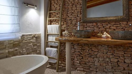 a bathroom with two sinks and a stone wall at Santa Eulalia - 4739 Ibiza in Cala Llonga