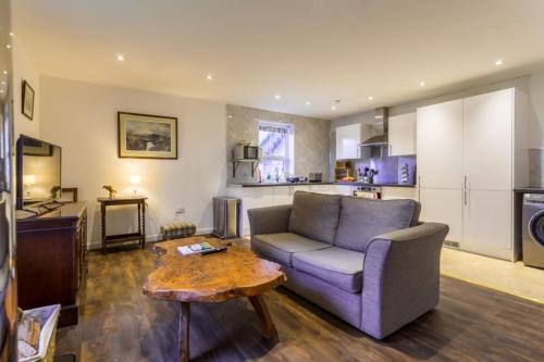 a living room with a couch and a table at The Bungalow - Ardullie Lodge in Dingwall