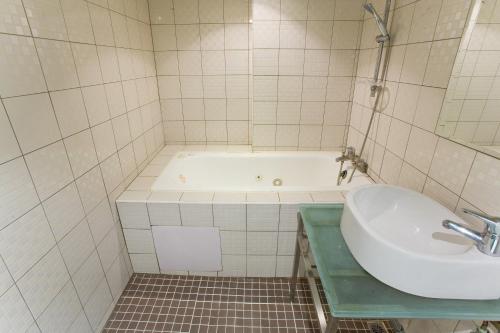 a bathroom with a tub and a sink at H.M.Hotel in Hsinchu City