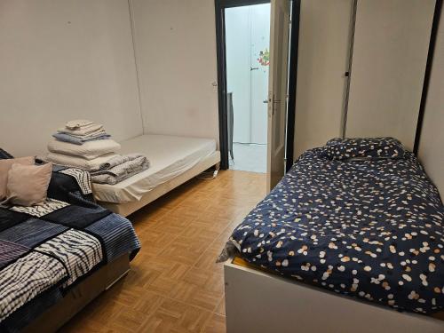Habitación con 2 camas y puerta al baño en chambre 5mn de paris, en Fontenay-sous-Bois