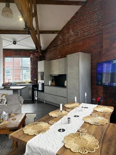 a living room with a table and a brick wall at Industrial Escape -Kelham Island in Sheffield