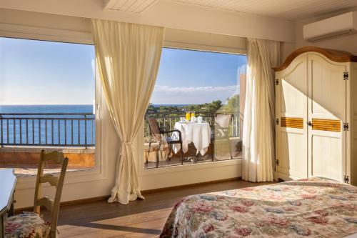 1 dormitorio con cama y ventana grande en Hotel BlauMar Llafranc en Llafranc