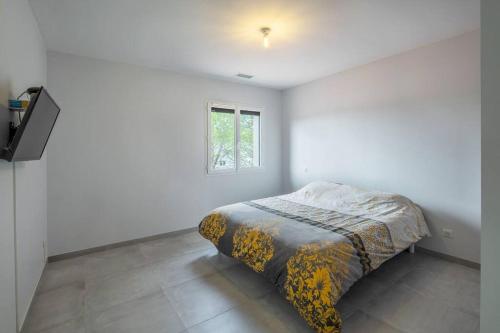 a bed in a white room with a window at villa micocouliers in Combaillaux