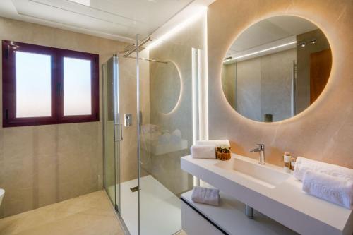 a bathroom with a shower and a sink and a mirror at Apartamentos Albir Confort 3 dormitorios in Albir