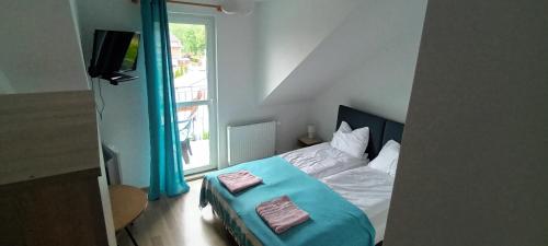 1 dormitorio con 1 cama con manta azul en Dom Wypoczynkowy PRZYLESIE7, en Międzywodzie