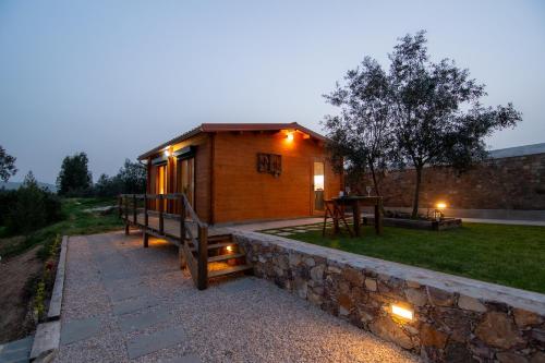 a small wooden cabin with a stone wall at Quinta do Esteval in Penacova