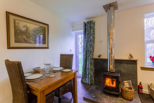 a dining room with a table and a wood stove at The Bungalow - Ardullie Lodge in Dingwall
