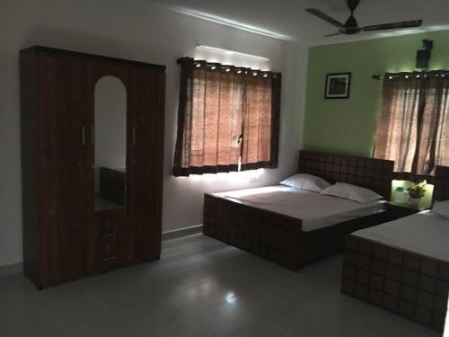 a bedroom with a bed and a mirror at JACK & JILL COTTAGE in Yelagiri