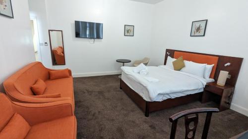a bedroom with a bed and a couch and a chair at Hotel Blackpool in Blackpool