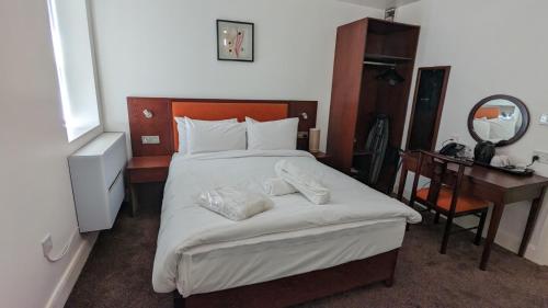 a bedroom with a bed with a desk and a mirror at Hotel Blackpool in Blackpool
