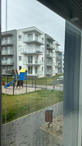 Il offre une vue sur un immeuble d'appartements doté d'une aire de jeux. dans l'établissement PORTA MARE KOŁOBRZEG Ul GEN MACZKA 29 3, à Kołobrzeg