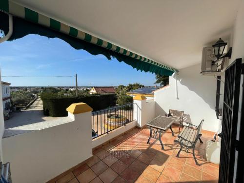Un balcón con dos sillas y una mesa. en Finca La Tacita - Jazmín, en Conil de la Frontera