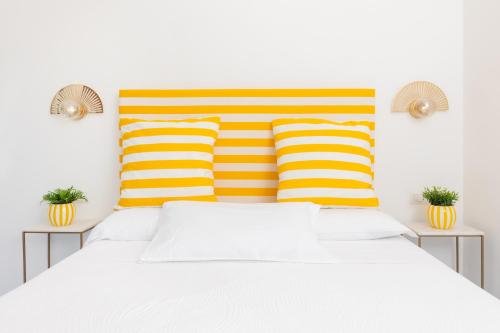 a bed with yellow and orange striped pillows at La Gloriette in Capri