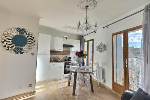 a kitchen and a dining room with a table in a room at Appartement de charme avec balcon au pied des commerces in Béziers