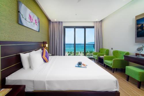 a hotel room with a bed with a view of the ocean at Alani Hotel & Spa in Danang